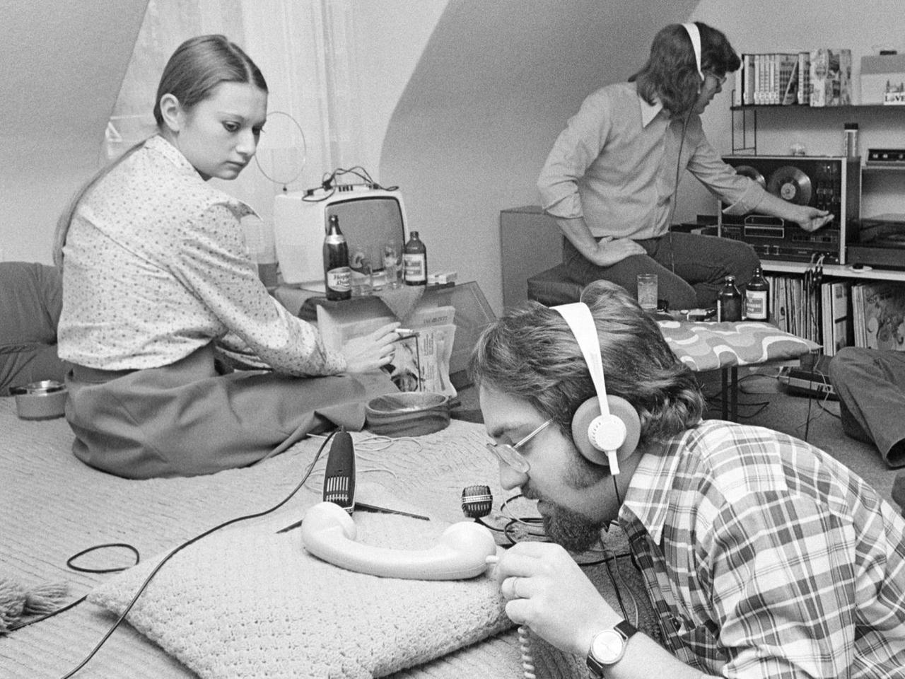 Junge Leute produzieren ein Hörspiel in Göttingen; auf dem schwarz/weiß-Bild sind drei junge Männer und eine Frau zu sehen, die in einem Wohnzimmer O-Ton-Aufnahmen für ein Hörspiel machen. Junge Leute produzieren ein Hörspiel in Göttingen; auf dem schwarz/weiß-Bild sind drei junge Männer und eine Frau zu sehen, die in einem Wohnzimmer O-Ton-Aufnahmen für ein Hörspiel machen.