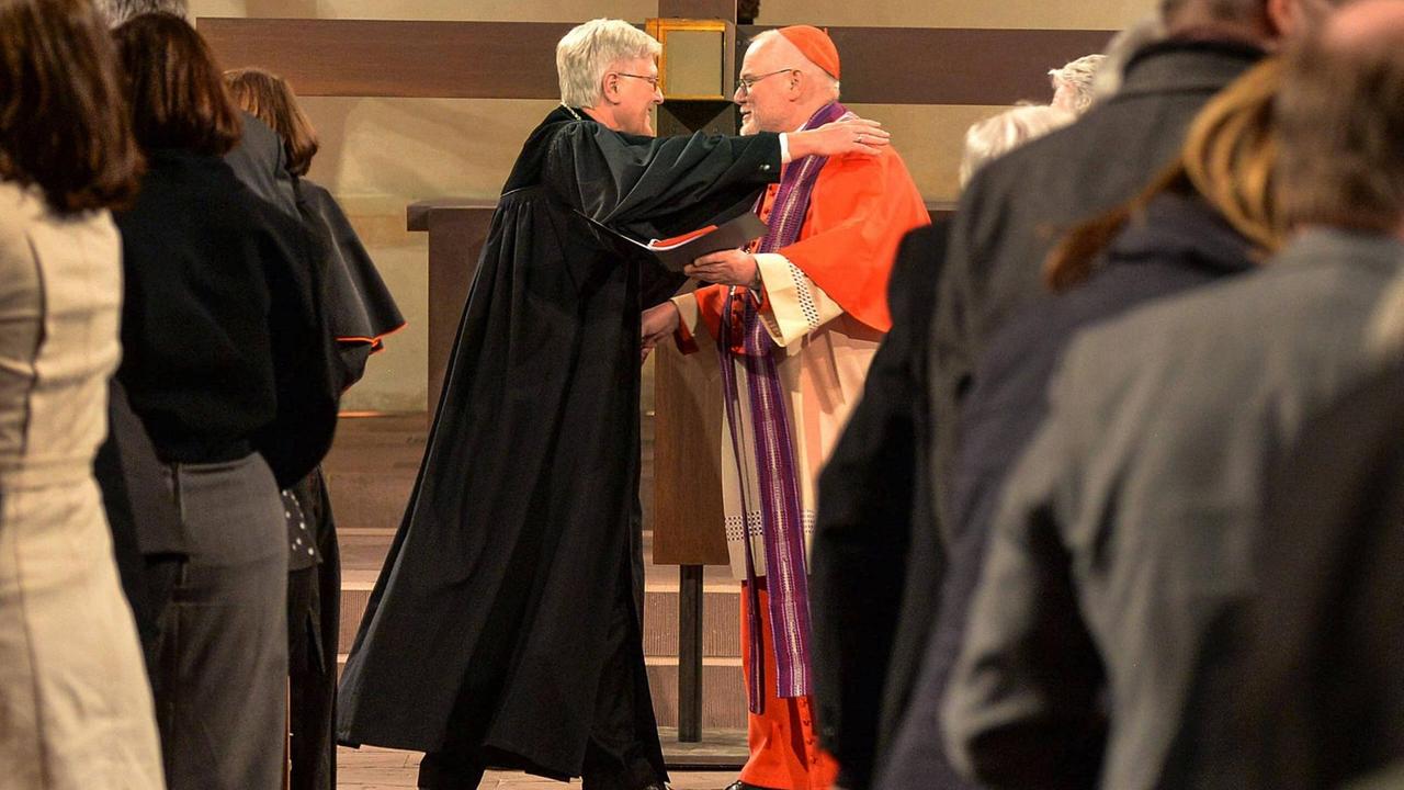 Der Ratsvorsitzende der Evangelischen Kirche in Deutschland Heinrich Bedford-Strohm und der Vorsitzende der katholischen Deutschen Bischofskonferenz Kardinal Reinhard Marx umarmen einander bei einem Gottesdienst in Hildesheim im März 2017 Der Ratsvorsitzende der Evangelischen Kirche in Deutschland Heinrich Bedford-Strohm und der Vorsitzende der katholischen Deutschen Bischofskonferenz Kardinal Reinhard Marx umarmen einander bei einem Gottesdienst in Hildesheim im März 2017