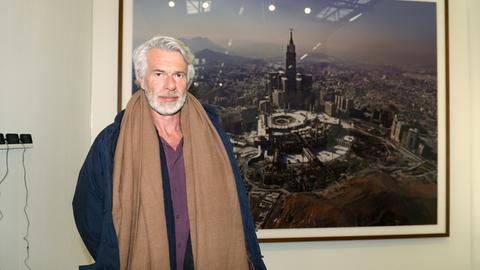 Chris Dercon, Direktor der Tate Gallery of Modern Art in London, auf der New Yorker Kunstmesse "The Armory Show" vor einem Bild des Künstlers Ahmed Mater, das die Stadt Mekka zeigt.
