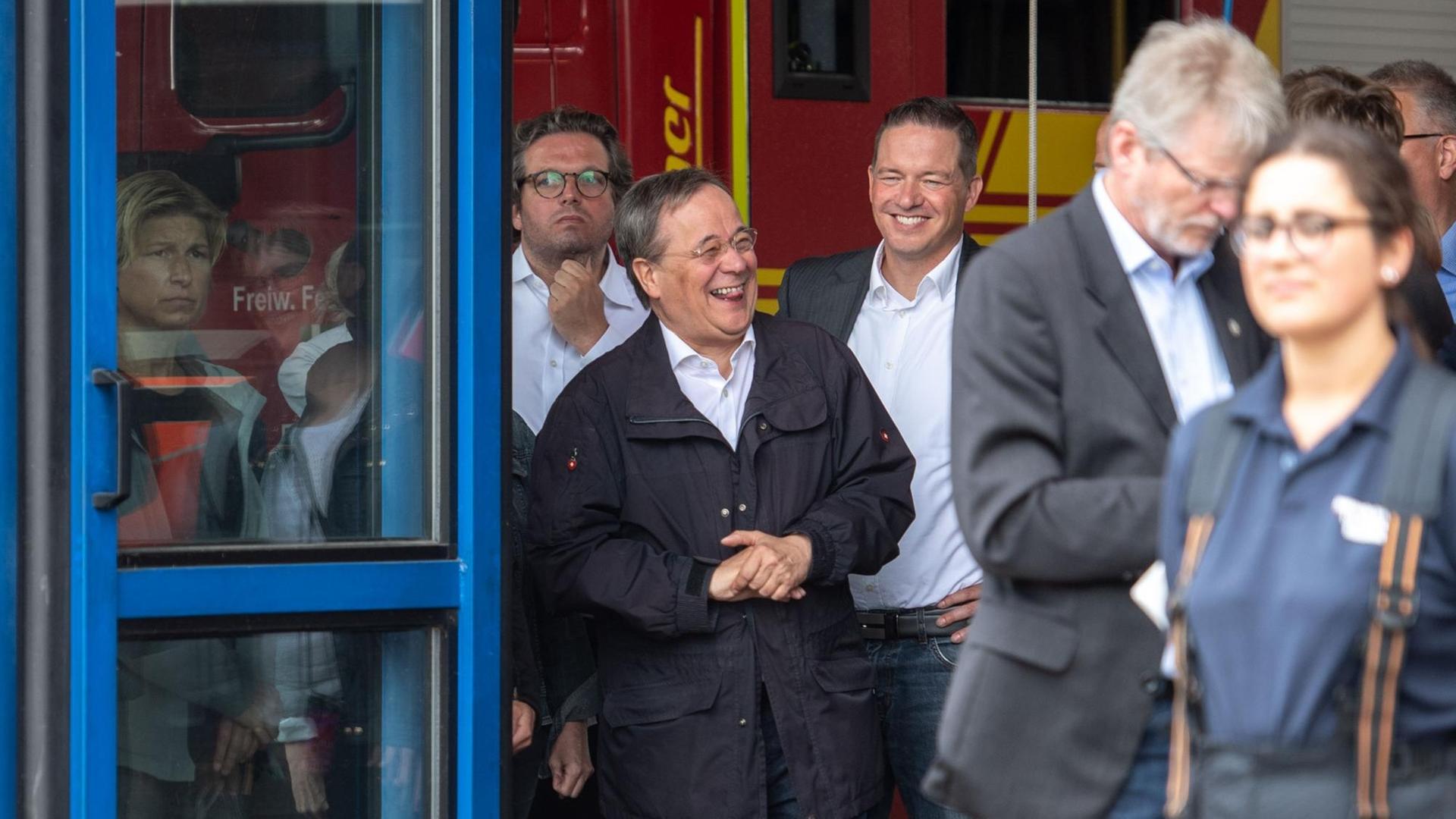 Armin Laschet (2. v.l., CDU), Ministerpräsident von Nordrhein-Westfalen, lacht während Bundespräsident Steinmeier (nicht im Bild) im Hochwassergebiet in Erftstadt ein Pressestatement gibt. Armin Laschet (2. v.l., CDU), Ministerpräsident von Nordrhein-Westfalen, lacht während Bundespräsident Steinmeier (nicht im Bild) im Hochwassergebiet in Erftstadt ein Pressestatement gibt.