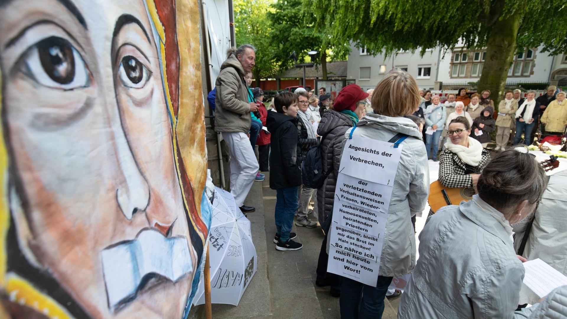Ein Transparent zeigt Maria, die Mutter Gottes, mit einem Pflaster auf dem Mund anlässlich eines Gottesdienstes unter freiem Himmel. Katholische Frauen und verschiedene Frauen-Initiativen aus mehreren deutschen Bistümern beteiligen sich am Kirchenstreik "Maria 2.0". Ein Transparent zeigt Maria, die Mutter Gottes, mit einem Pflaster auf dem Mund anlässlich eines Gottesdienstes unter freiem Himmel. Katholische Frauen und verschiedene Frauen-Initiativen aus mehreren deutschen Bistümern beteiligen sich am Kirchenstreik "Maria 2.0".