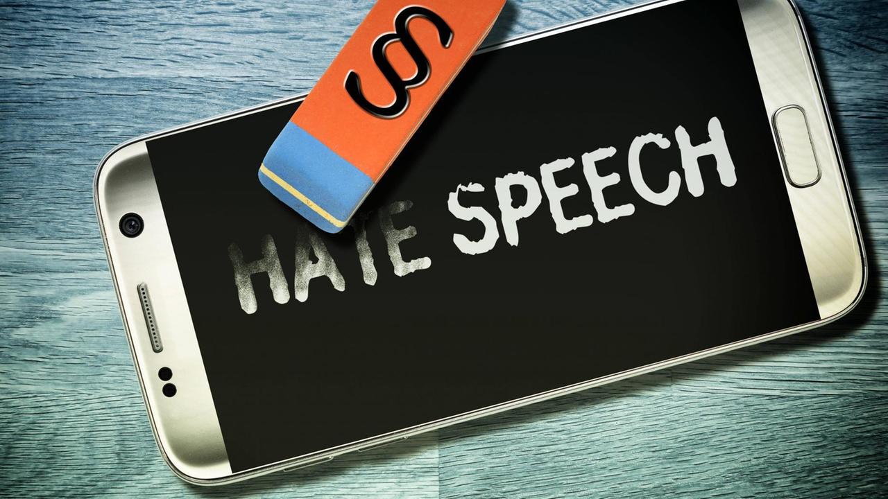 Der Schriftzug "Hate Speech" auf einem Handydisplay wird wegradiert, Symbolfoto zum Netzwerkdurchsetzungsgesetz *** The writing "hate speech" on a cell phone s display is erased. icon photo for the planned network enforcement law Der Schriftzug "Hate Speech" auf einem Handydisplay wird wegradiert, Symbolfoto zum Netzwerkdurchsetzungsgesetz *** The writing "hate speech" on a cell phone s display is erased. icon photo for the planned network enforcement law