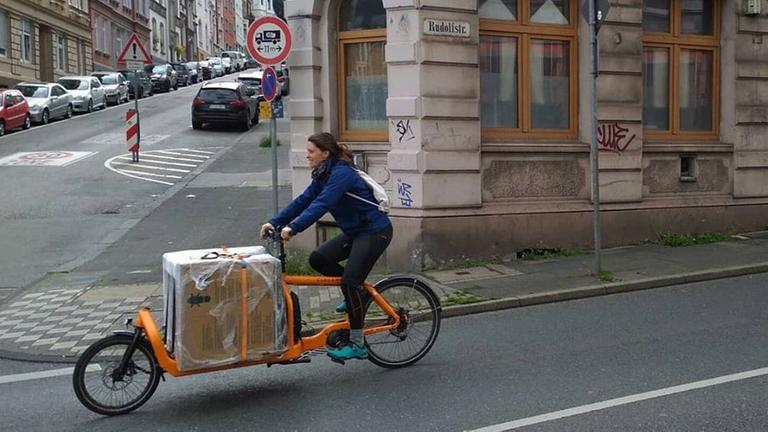 Kirsten Haberer transportiert ihre Spülmaschine mit ihrem Lastenrad.