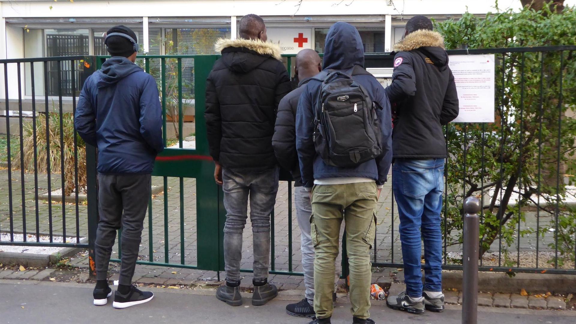 Junge Migranten vor der Rot-Kreuz-Behörde in Paris Junge Migranten vor der Rot-Kreuz-Behörde in Paris