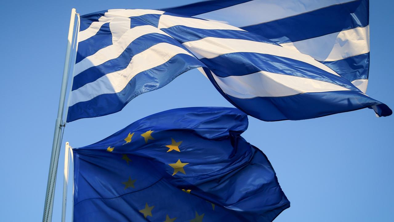 Die griechische und europäische Fahne wehen am Himmel