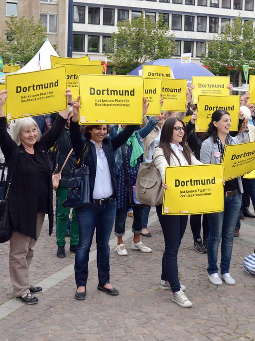 Bürger halten in Dortmund (Nordhein-Westfalen) vor dem Rathaus während einer Demonstration Schilder gegen Rechtsextremismus hoch.