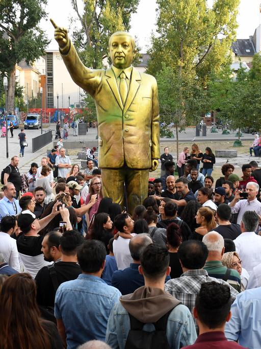 Zahlreiche Menschen haben sich auf dem Platz der Deutschen Einheit vor einer goldenen Erdogan-Statue in Wiesbaden versammelt. Die Statue wurde im Rahmen des Kunstfestivals "Wiesbaden Biennale" aufgestellt.