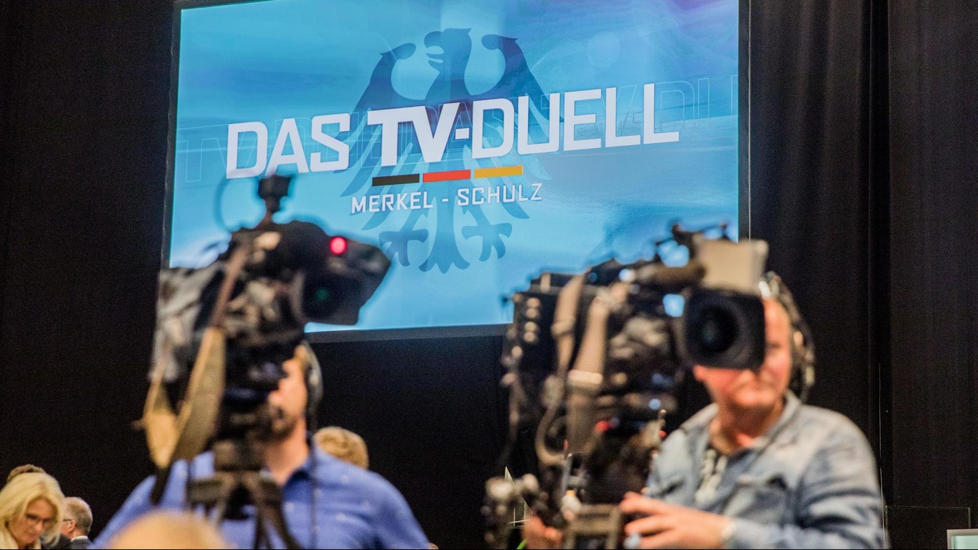 Kameras filmen im Fernsehstudio Adlershof die Pressekonferenz zum TV-Duell anlässlich der Bundestagswahl 2017. Im Hintergrund das Logo des TV-Duells an einer Wand zu sehen. Kameras filmen im Fernsehstudio Adlershof die Pressekonferenz zum TV-Duell anlässlich der Bundestagswahl 2017. Im Hintergrund das Logo des TV-Duells an einer Wand zu sehen.