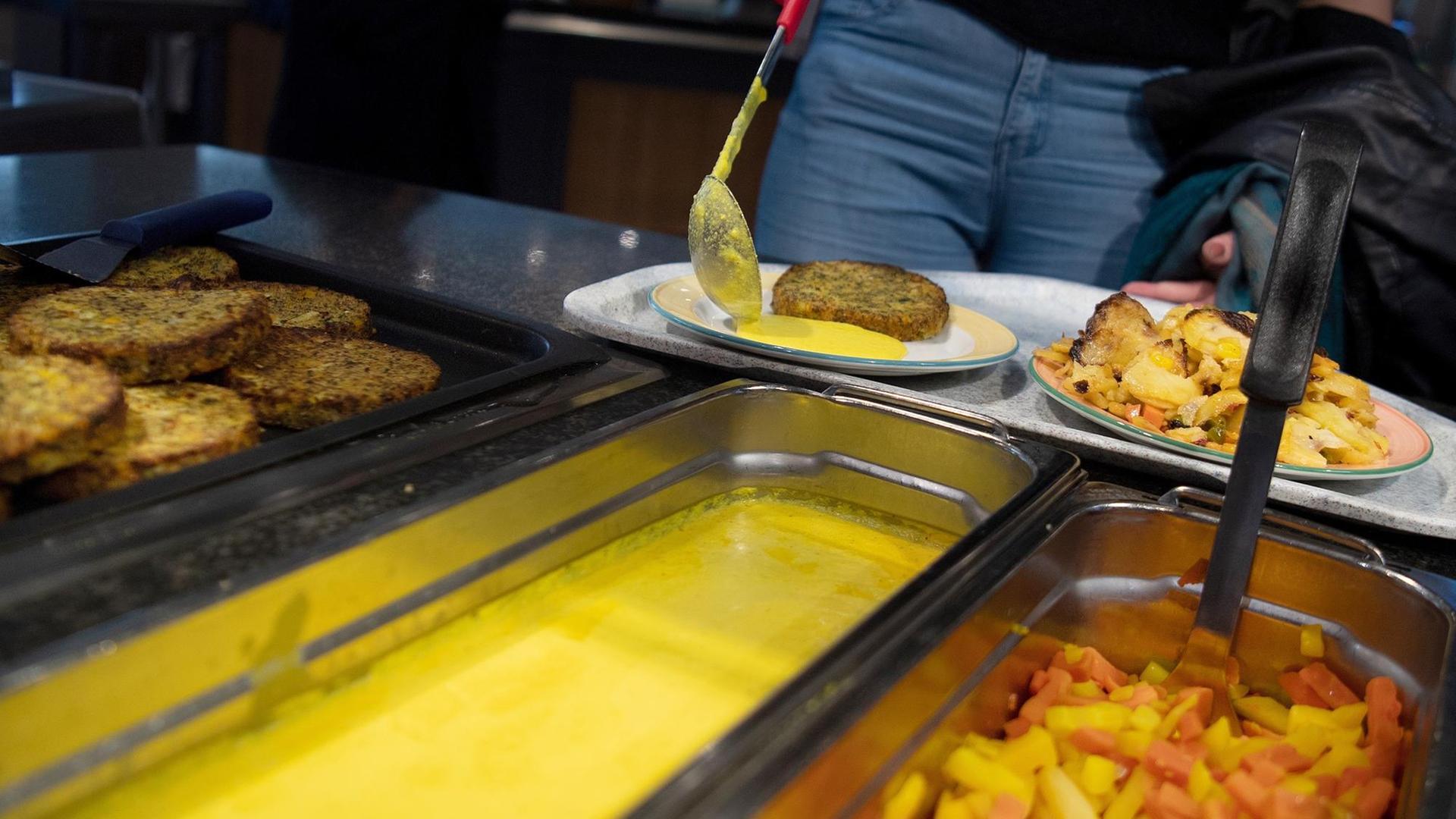 Eine Studentin füllt ihren Teller in der veganen Mensa auf dem Campus der Technischen Universität. Eine Studentin füllt ihren Teller in der veganen Mensa auf dem Campus der Technischen Universität.
