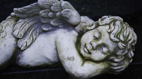Ein Engel liegt auf einem Grab auf dem Hauptfriedhof in Frankfurt am Main, aufgenommen am 17.04.2009.