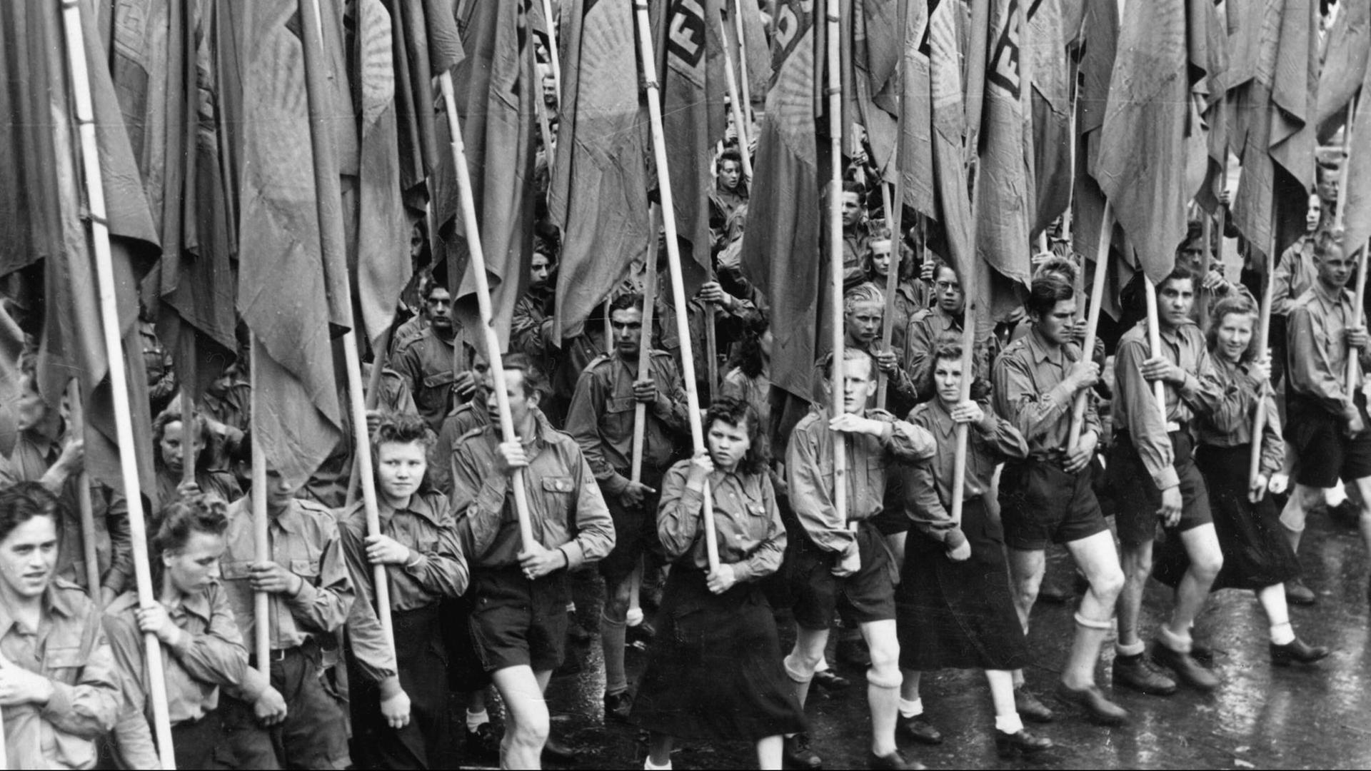 Mitglieder der "Freien Deutschen Jugend" tragen Fahnen der FDJ auf dem Weg zum Lustgarten in Berlin Mitglieder der "Freien Deutschen Jugend" tragen Fahnen der FDJ auf dem Weg zum Lustgarten in Berlin