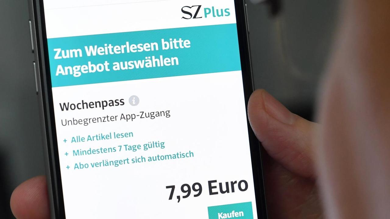 Eine Frau hält am ein Smartphone in der Hand, mit dem sie das Internet-Portal der Süddeutschen Zeitung aufgerufen hat.