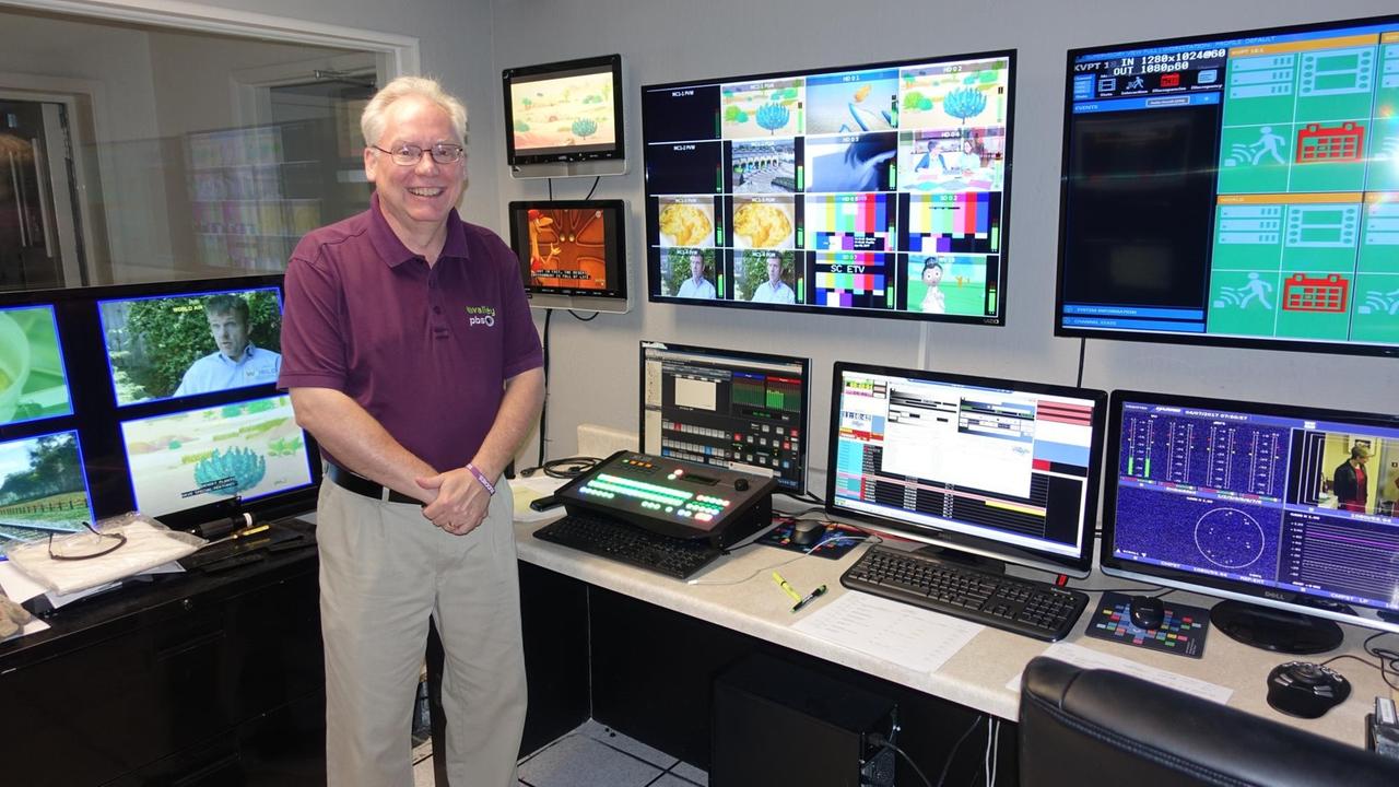 Phil Meyer steht in einem Schaltraum von Valley PBS und blickt in die Kamera. Hinter ihm sind mehrere Bildschirme und Computer zu sehen Phil Meyer steht in einem Schaltraum von Valley PBS und blickt in die Kamera. Hinter ihm sind mehrere Bildschirme und Computer zu sehen
