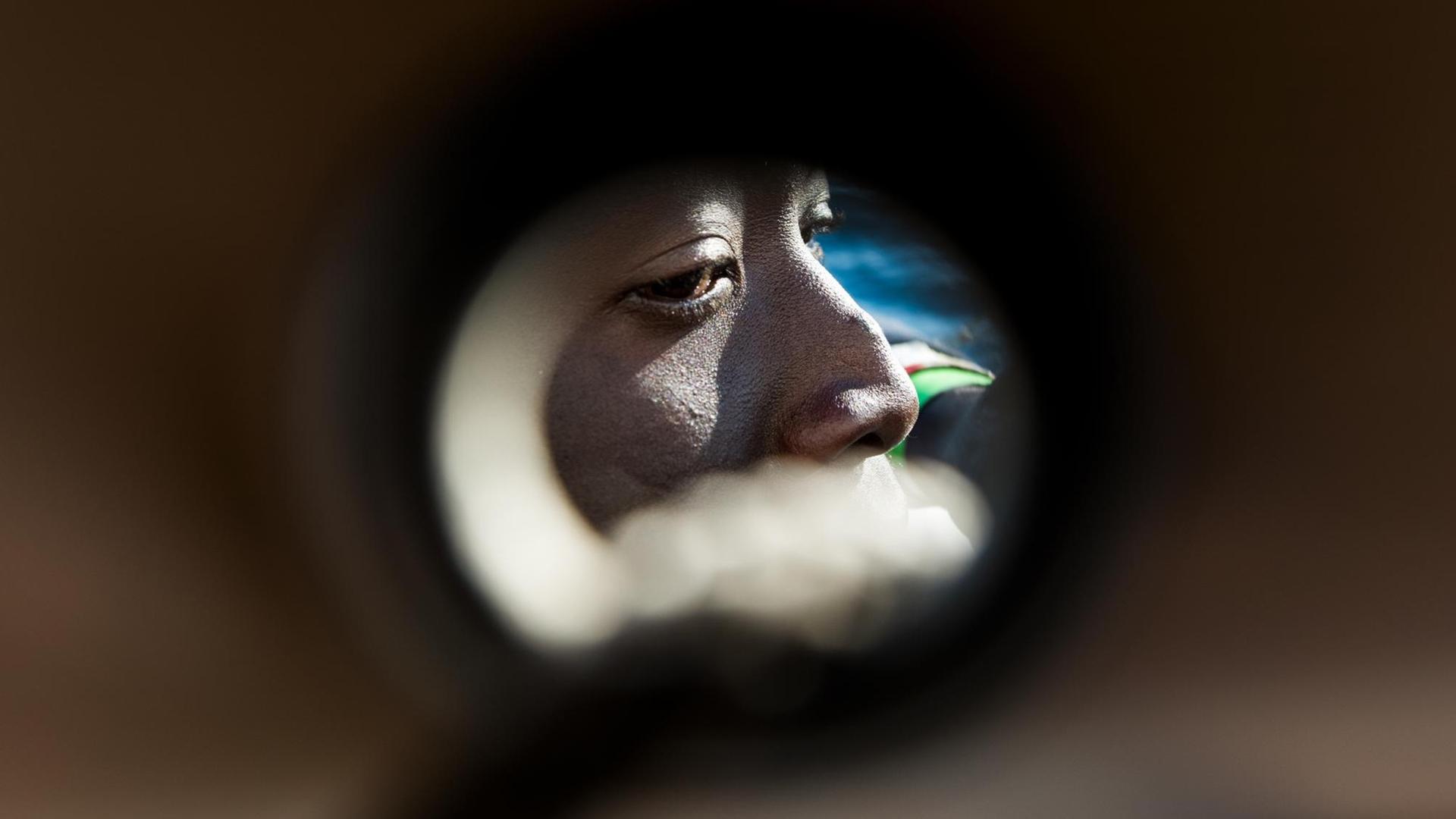 Das Gesicht eines Geflüchteten ist durch ein Guckloch hindurch zusehen, aufgenommen auf der MS Aquarius von SOS Mediterranee und Ärzte ohne Grenzen am 30.01.2018