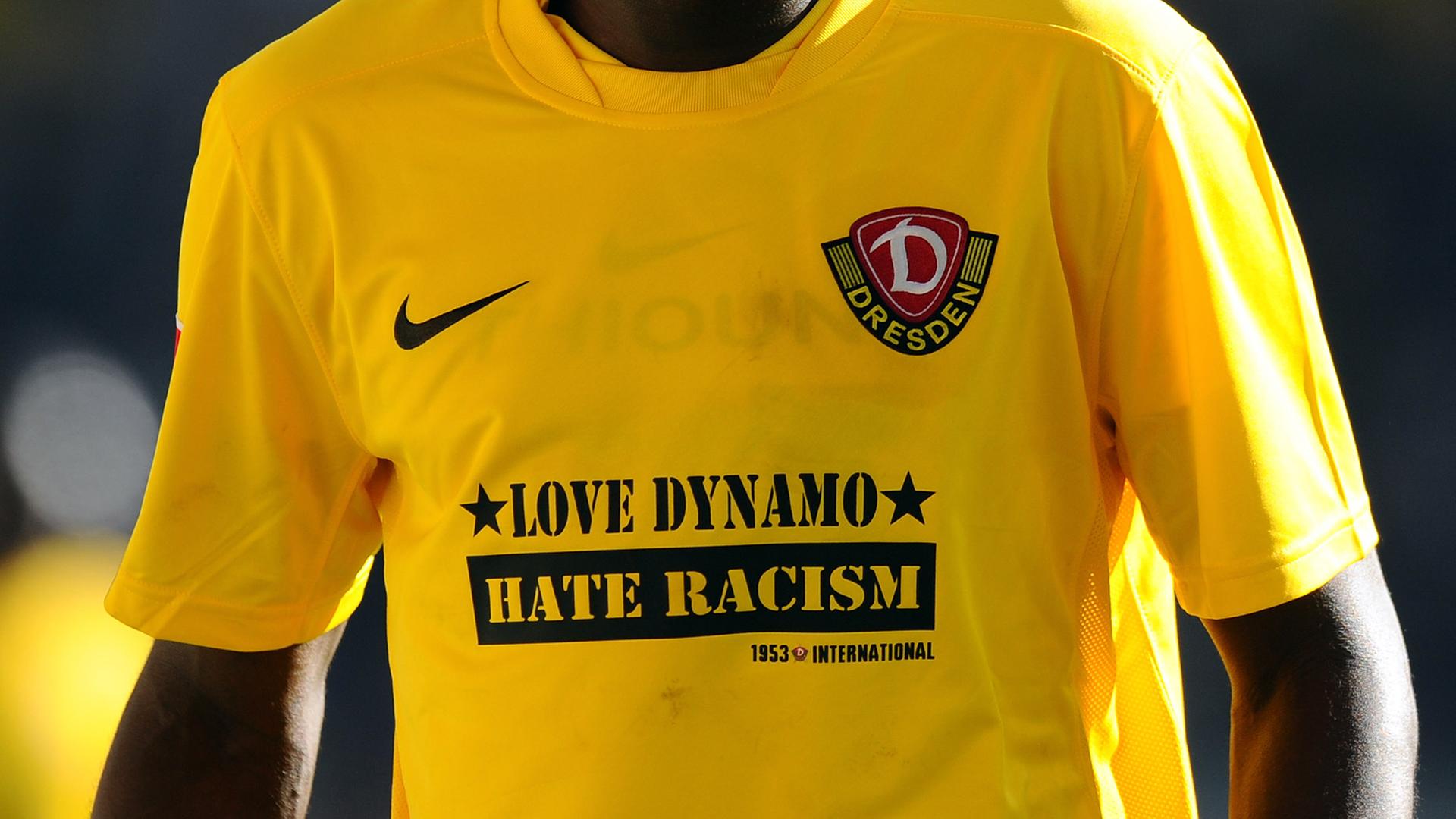 Ein dunkelhäutiger Fußballer trägt ein Trikot vom SG Dynamo Dresden mit dem Slogan "Love Dynamo Hate Racism" Ein dunkelhäutiger Fußballer trägt ein Trikot vom SG Dynamo Dresden mit dem Slogan "Love Dynamo Hate Racism"