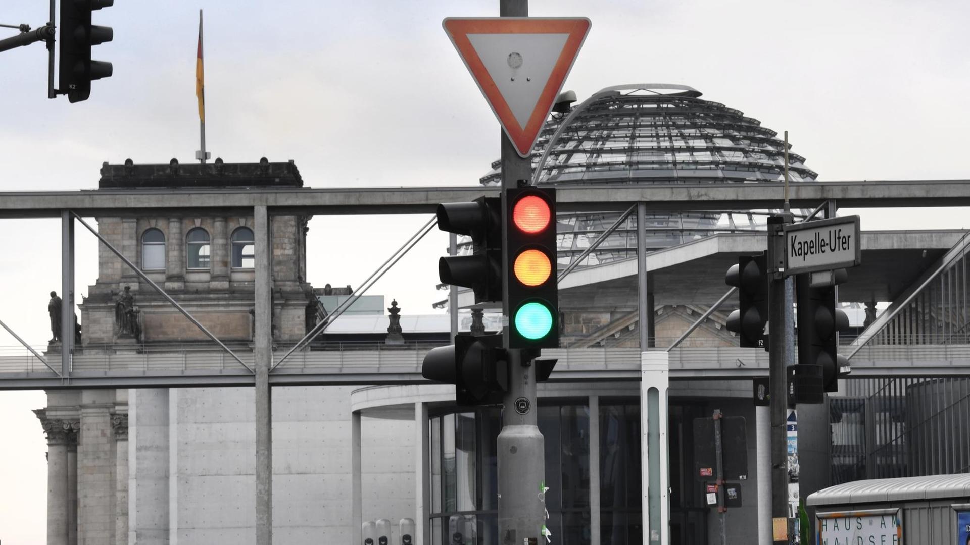 Eine Ampel, an der für einen Moment die Farben Rot, Gelb und Grün gleichzeitig leuchten, ist am Tag nach der Bundestagswahl im Regierungsviertel vor der Kuppel des Reichstagsgebäudes, dem Sitz des Bundestags, zu sehen. Eine Ampel, an der für einen Moment die Farben Rot, Gelb und Grün gleichzeitig leuchten, ist am Tag nach der Bundestagswahl im Regierungsviertel vor der Kuppel des Reichstagsgebäudes, dem Sitz des Bundestags, zu sehen.