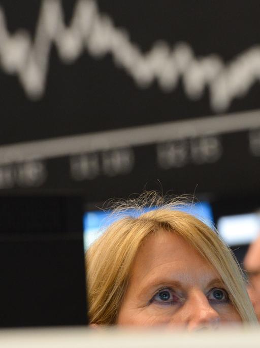 Eine Börsenhändlerin beobachtet auf dem Parkett der Wertpapierbörse in Frankfurt am Main ihre Monitore, die Verluste anzeigen.