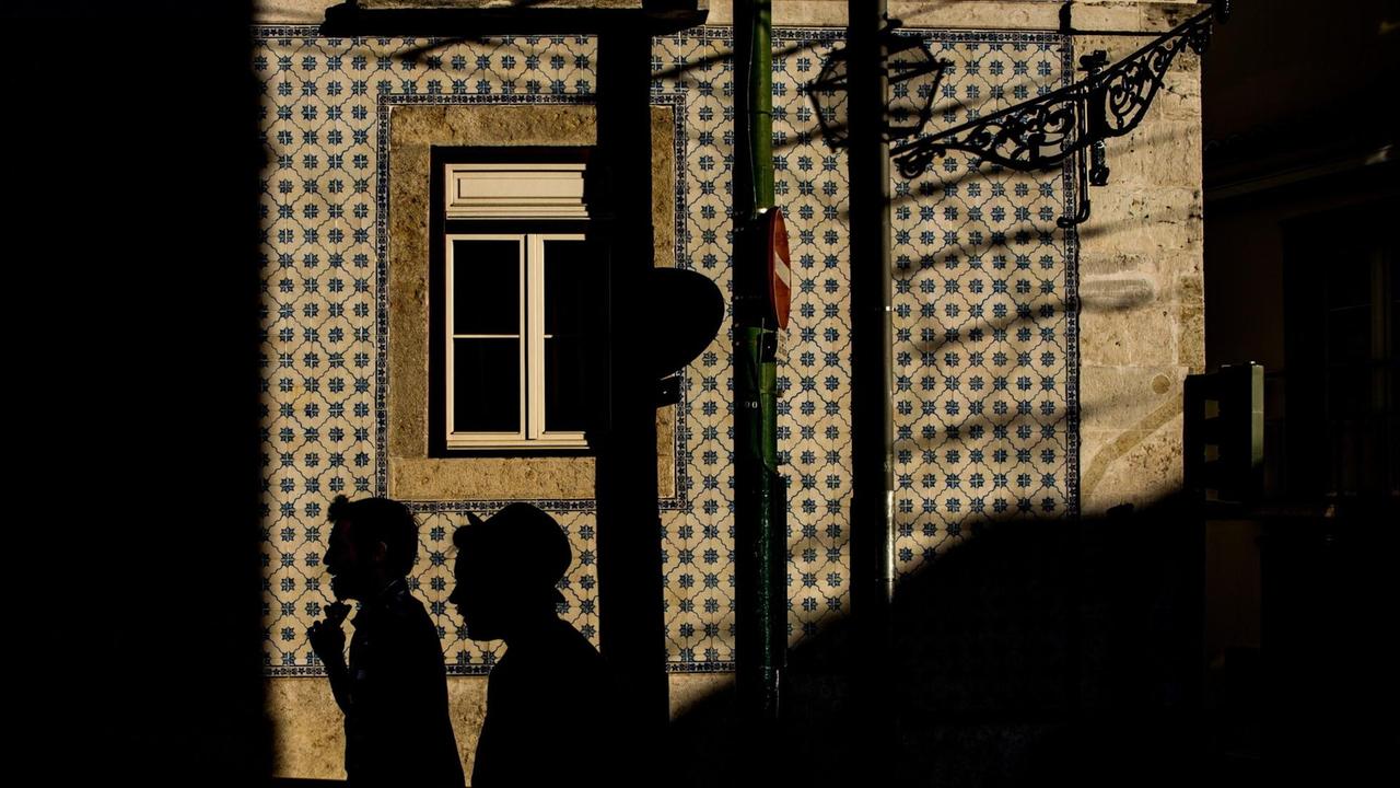 epaselect epa04664191 Two men walk in a street of Alfama neighbourhood during late afternoon in Lisbon, Portugal, 15 March 2015. Alfama is the oldest neighborhood in Lisbon. EPA/FILIP SINGER |
