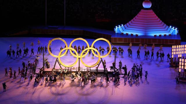 Japan, Tokio: Olympia: Eröffnungsfeier im Olympiastadion. Olympische Ringe werden während der Show zusammengeführt.