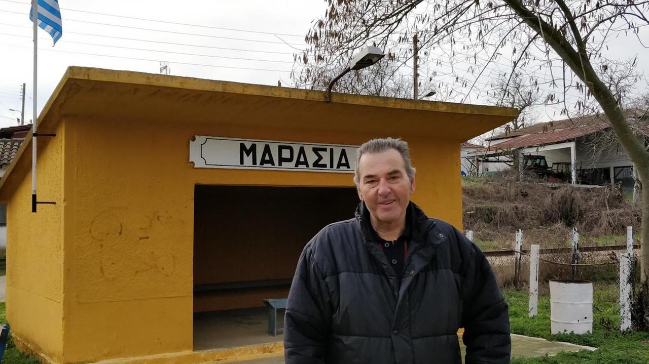 Giorgos Chatzigagidis, Gemeindevorsitzende von Marasia, steht vor einer Haltestelle am Bahnhof Giorgos Chatzigagidis, Gemeindevorsitzende von Marasia, steht vor einer Haltestelle am Bahnhof