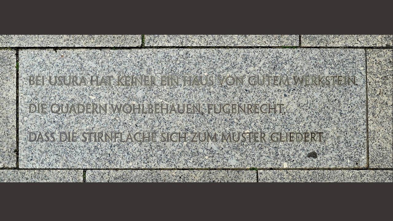 Auf einer Steinplatte ist folgender Text zu lesen: "Bei Usura hat keiner ein Haus von gutem Werkstein / die Quadern wohlbehauen, fugenrecht, / dass die Stirnfläche sich zum Muster gliedert." Auf einer Steinplatte ist folgender Text zu lesen: "Bei Usura hat keiner ein Haus von gutem Werkstein / die Quadern wohlbehauen, fugenrecht, / dass die Stirnfläche sich zum Muster gliedert."
