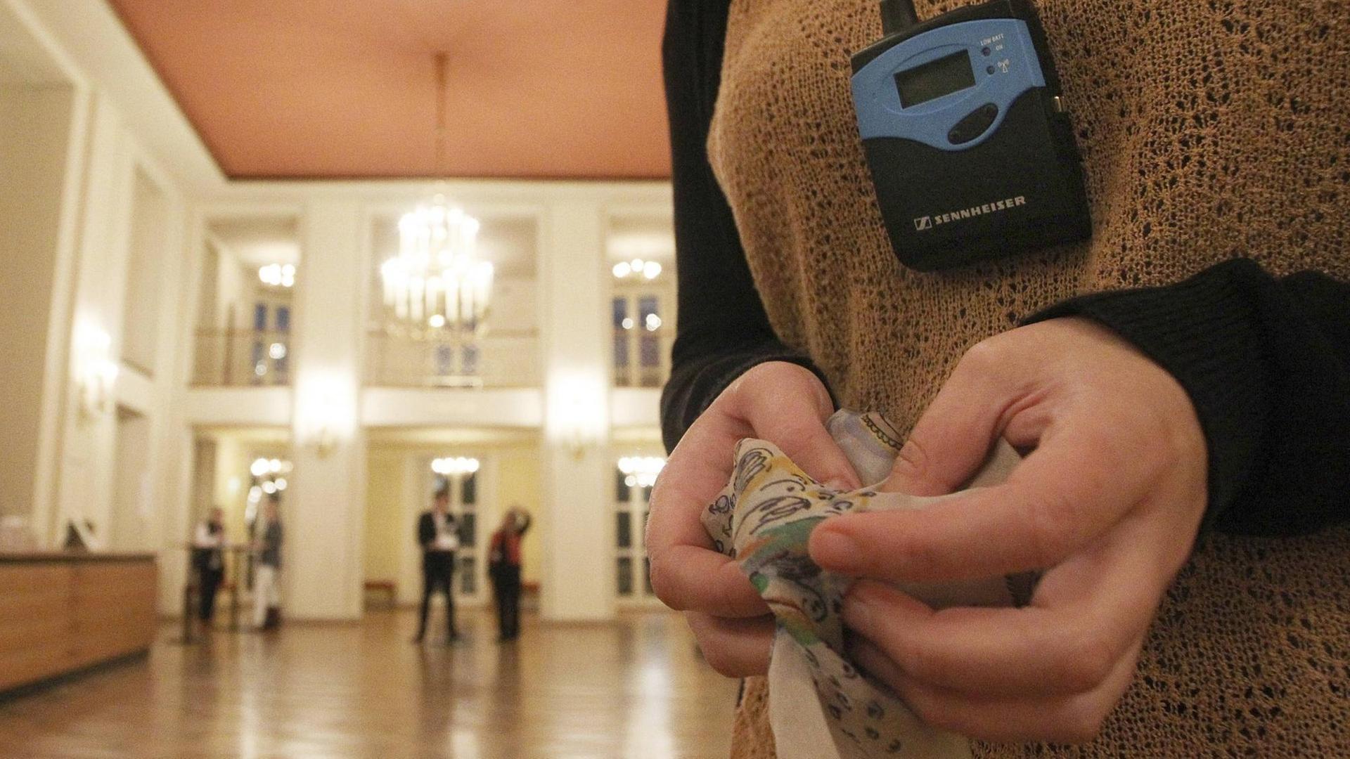 Die Besucherin einer Theaterführung für Blinde und Sehbehinderte ertastet im Leipziger Schauspiel Stoffe die bei der Theateraufführung verwendet werden. Um den Hals trägt sie ein Gerät zur Audiodeskription. Die Besucherin einer Theaterführung für Blinde und Sehbehinderte ertastet im Leipziger Schauspiel Stoffe die bei der Theateraufführung verwendet werden. Um den Hals trägt sie ein Gerät zur Audiodeskription.