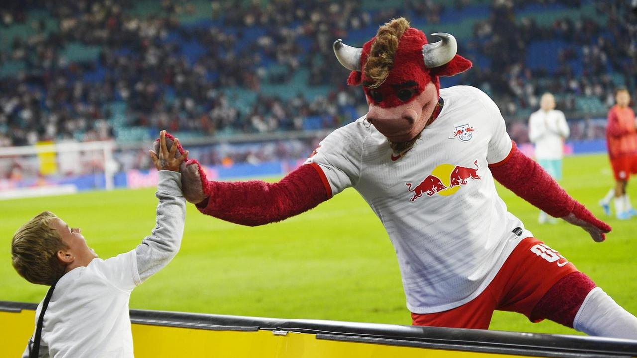 RB Leipzig-Maskottchen Bulli klatscht nach dem Bundesliga-Spiel einen kleinen Fan ab.