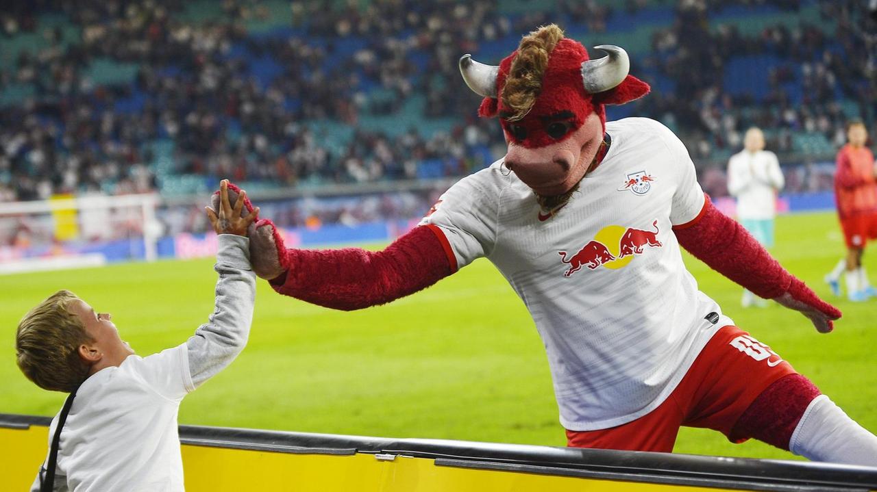 RB Leipzig-Maskottchen Bulli klatscht nach dem Bundesliga-Spiel einen kleinen Fan ab. RB Leipzig-Maskottchen Bulli klatscht nach dem Bundesliga-Spiel einen kleinen Fan ab.