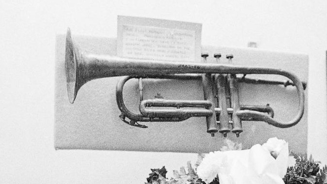 In einer Gedenkvirtrine hängt das leicht verbeulte Blechblasinstrument. In einer Gedenkvirtrine hängt das leicht verbeulte Blechblasinstrument.
