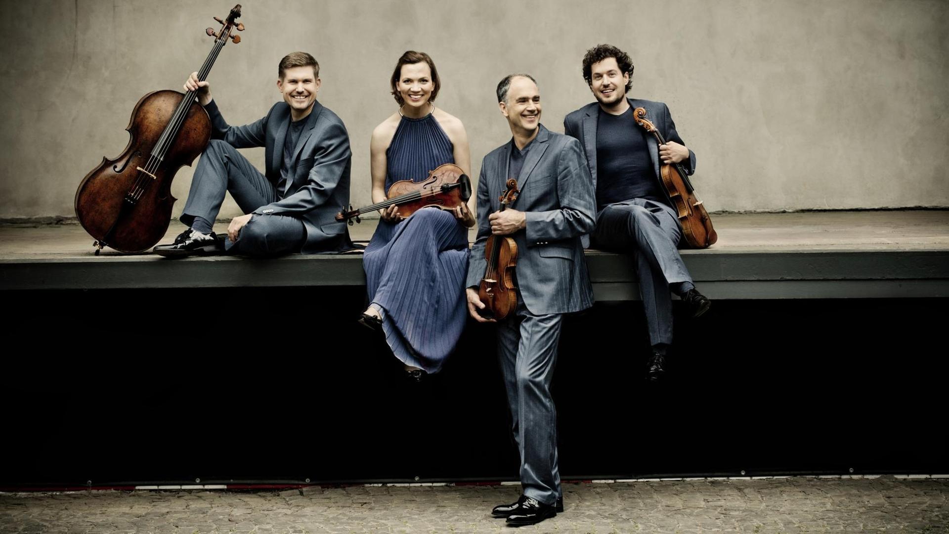 Die vier Musiker des Signum Quartetts mit ihren Streichinstrumenten. Die vier Musiker des Signum Quartetts mit ihren Streichinstrumenten.