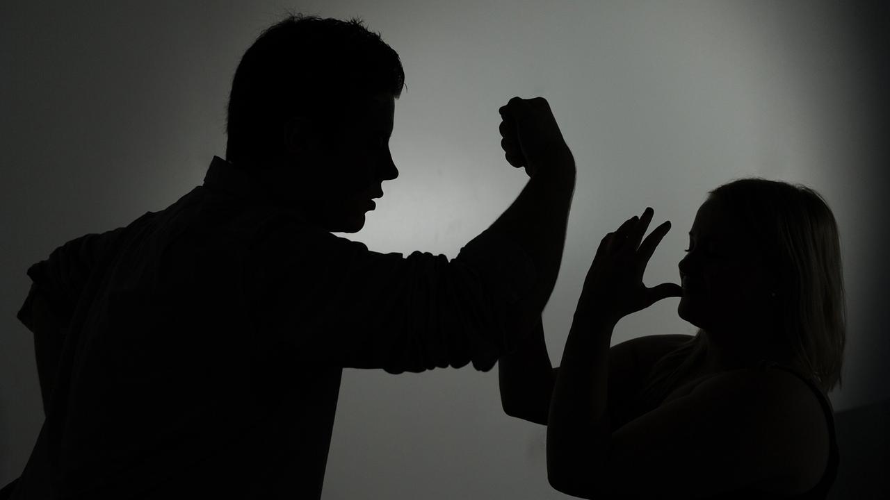Eine Mann droht einer Frau mit der Faust. Eine Mann droht einer Frau mit der Faust.