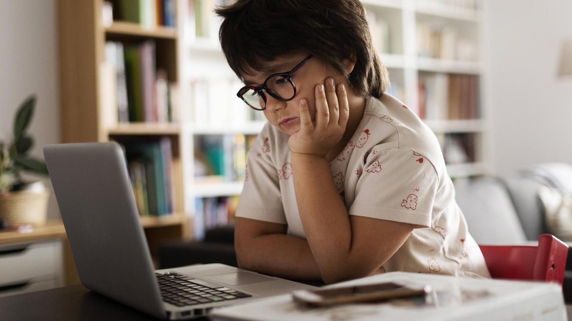 Kind hängt genervt vorm Laptop Kind hängt genervt vorm Laptop