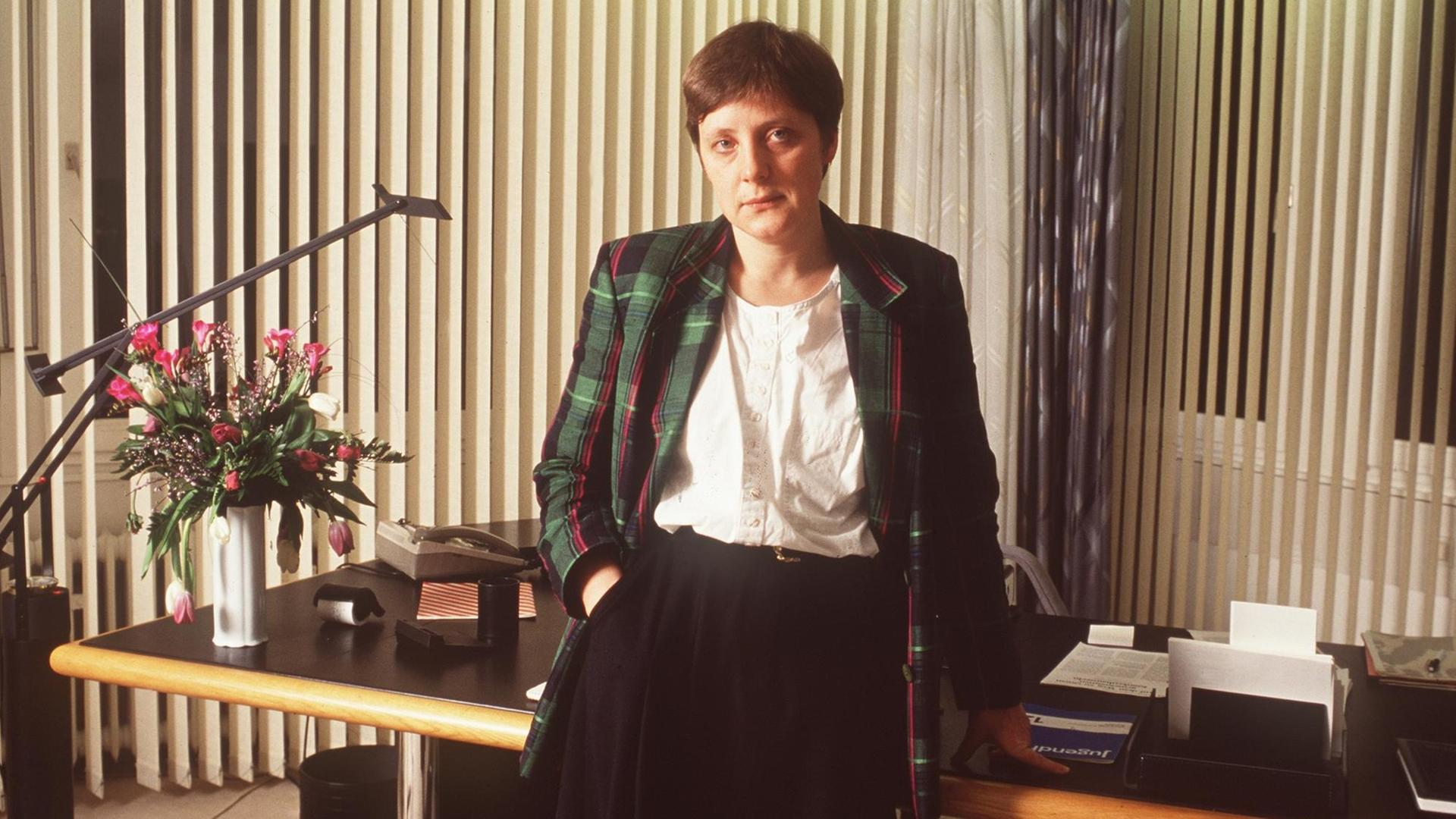 Angela Merkel als Bundesministerin für Frauen und Jugend (1991) steht am Schreibtisch in ihrem Büro in Bonn.