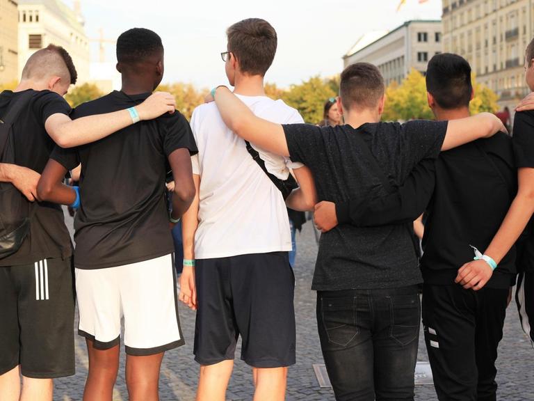 Jugendliche posieren in Berlin für ein Foto, manche davon mit Migrationshintergrund.