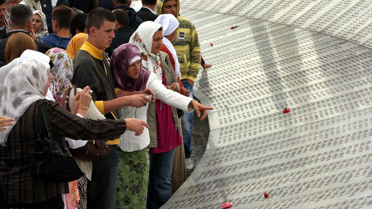 Besucher lesen die Namen von bosnischen Muslimen, die beim Massaker vom Srebrenica umgebracht worden. Besucher lesen die Namen von bosnischen Muslimen, die beim Massaker vom Srebrenica umgebracht worden.
