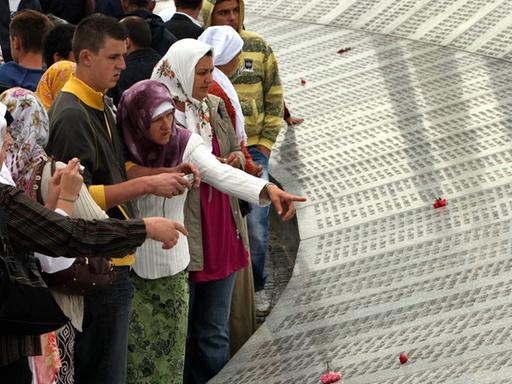 Besucher lesen die Namen von bosnischen Muslimen, die beim Massaker vom Srebrenica umgebracht worden.