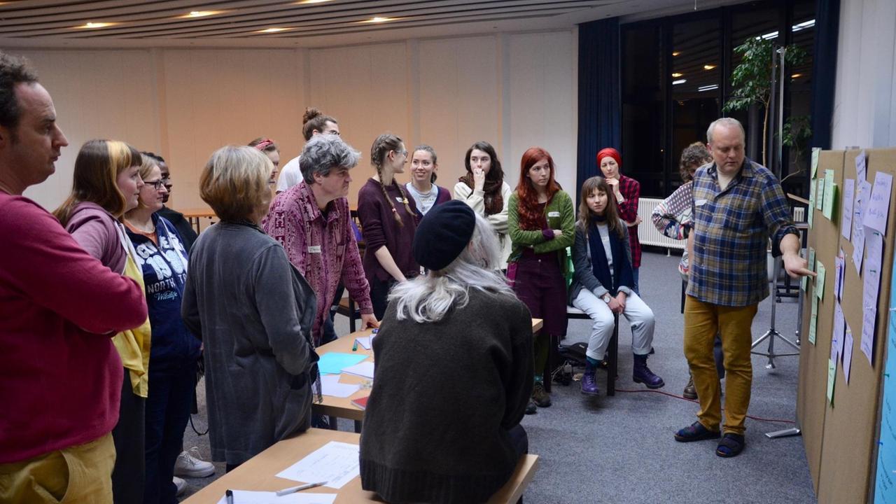 Teilnehmer der Zukunftswerkstatt Musik und Klima stehen in einem Veranstaltungsraum in Hamburg vor einer Pinwand. Teilnehmer der Zukunftswerkstatt Musik und Klima stehen in einem Veranstaltungsraum in Hamburg vor einer Pinwand.