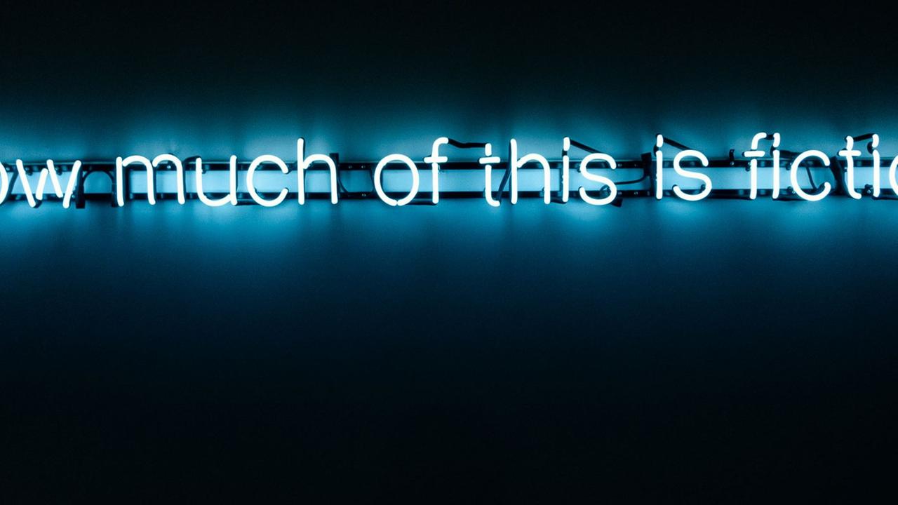 Ein weißer Schriftzug mit "how much of this is fiction.", der blau unterlegt ist. der Rest des Bildes ist schwarz. Ein weißer Schriftzug mit "how much of this is fiction.", der blau unterlegt ist. der Rest des Bildes ist schwarz.