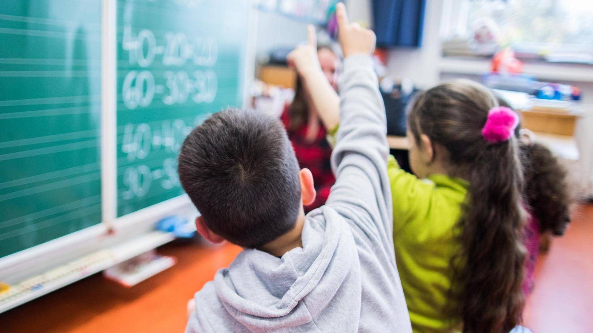 Ein Junge zeigt in Essen in der Maria-Kunigunda-Grundschule während einer Mathe-Übung auf. Ein Junge zeigt in Essen in der Maria-Kunigunda-Grundschule während einer Mathe-Übung auf.