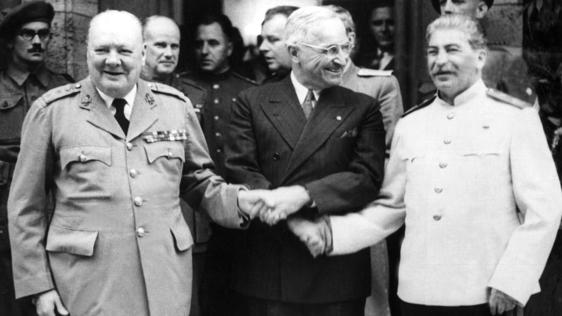 Der britische Premierminister Winston Churchill, der amerikanische Präsident Harry S. Truman und der sowjetische Diktator Josef Stalin (v.l.) reichen sich während der Potsdamer Konferenz im Juli 1945 die Hände.