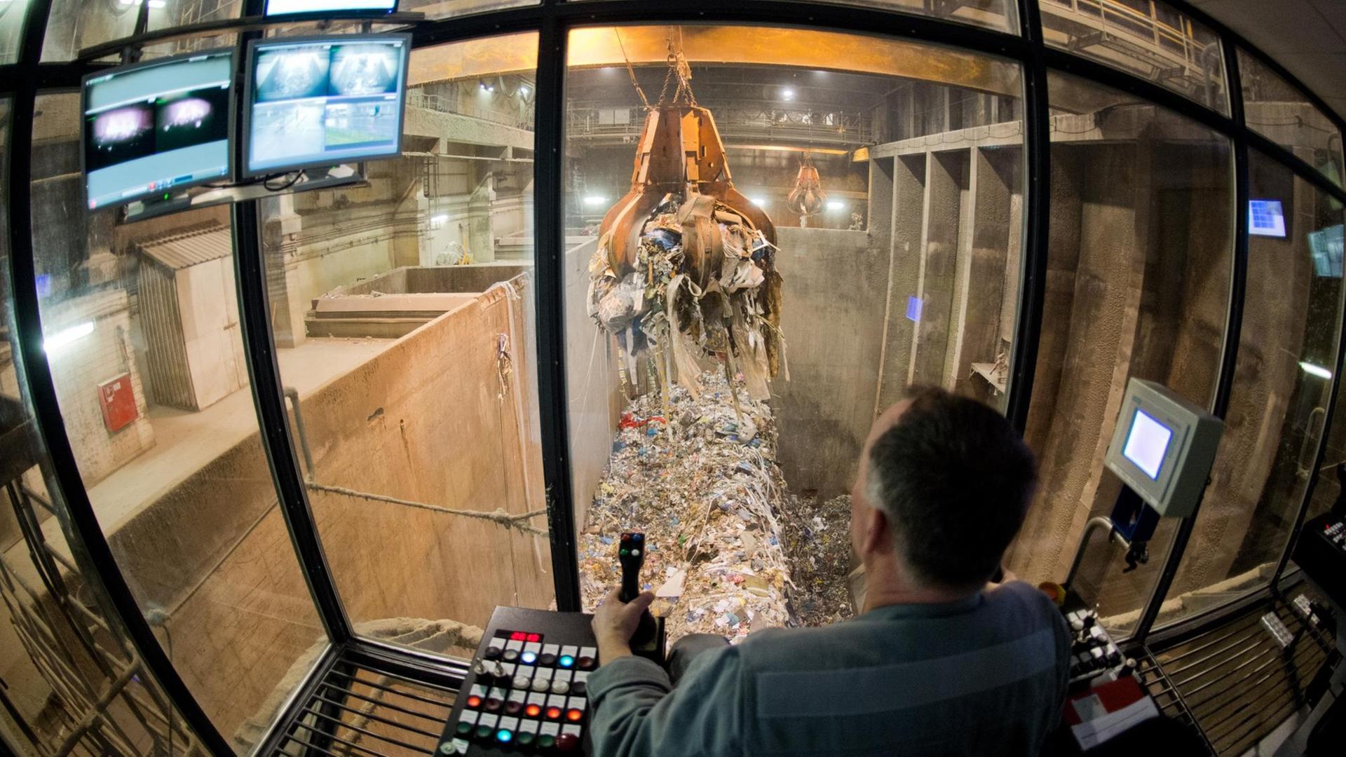 Ein Kraftwerker transportiert Müll mit einem Kran zum Verbrennen in einer Müllverbrennungsanlage der EEW Energy from Waste in Hannover. Ein Kraftwerker transportiert Müll mit einem Kran zum Verbrennen in einer Müllverbrennungsanlage der EEW Energy from Waste in Hannover.