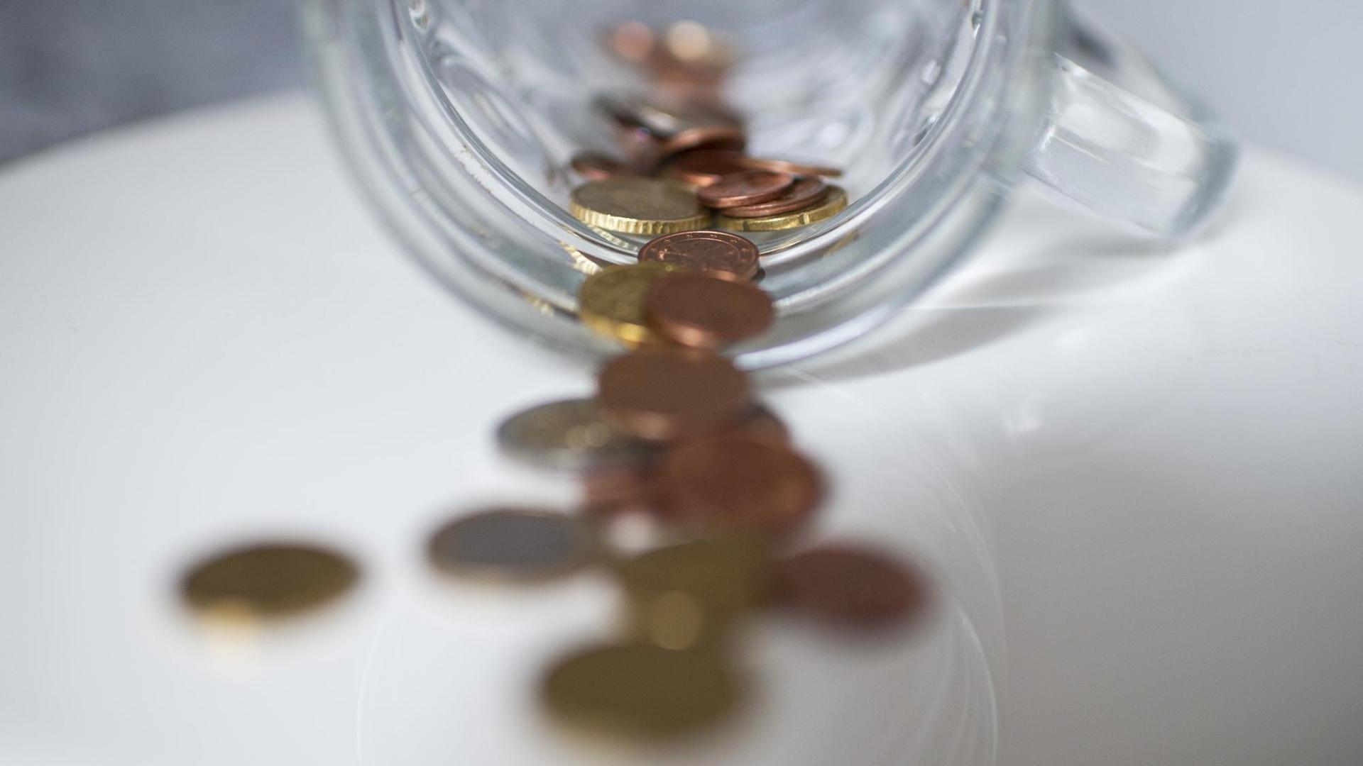 Geld in Form von Münzen liegt auf einer Ablagefläche Geld in Form von Münzen liegt auf einer Ablagefläche