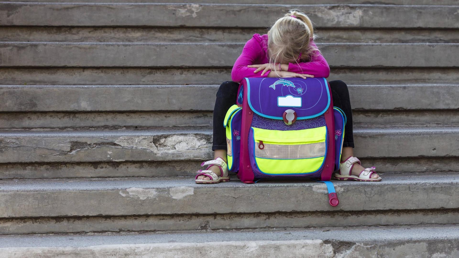 Ein trauriges Mädchen sitzt auf einer Treppe. Ein trauriges Mädchen sitzt auf einer Treppe.