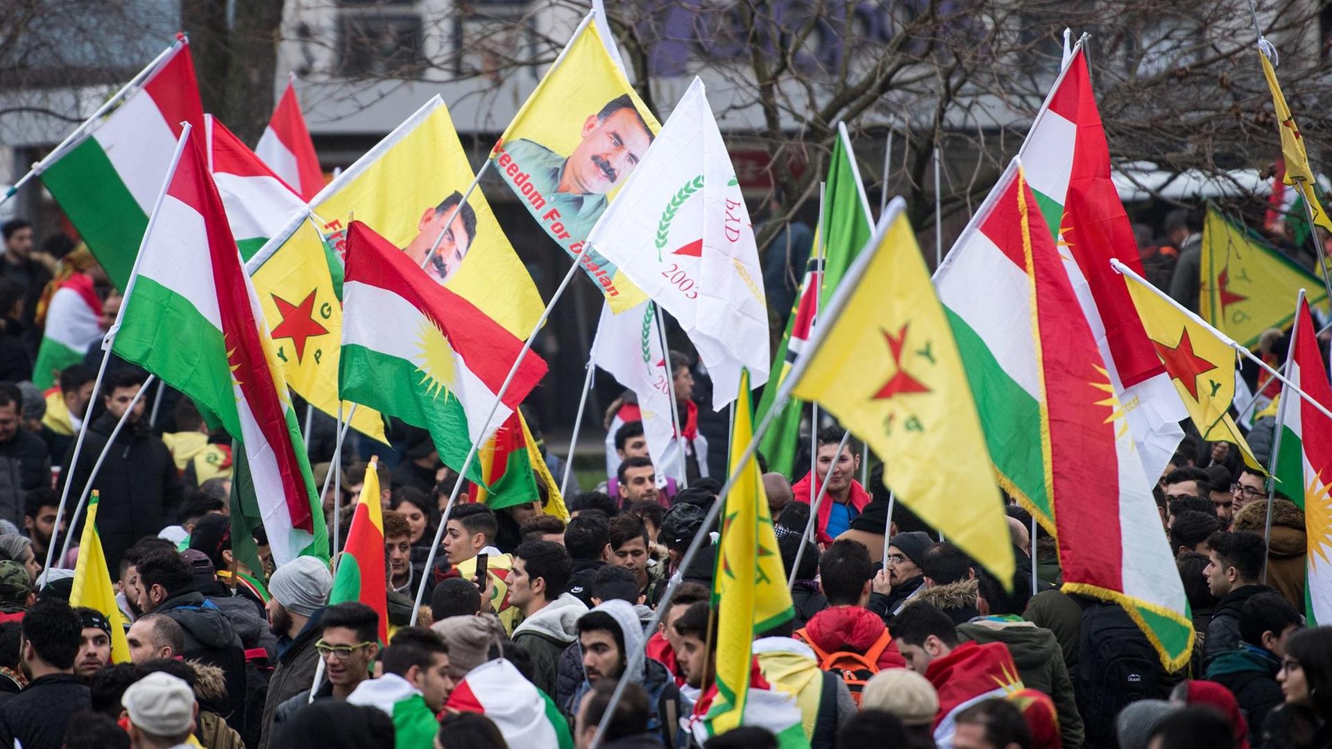 Teilnehmer einer Kurden-Demo gegen die türkische Militäroffensive in Nordsyrien versammeln sich am 27.01.2018 in Köln und halten kurdische Fahnen hoch.