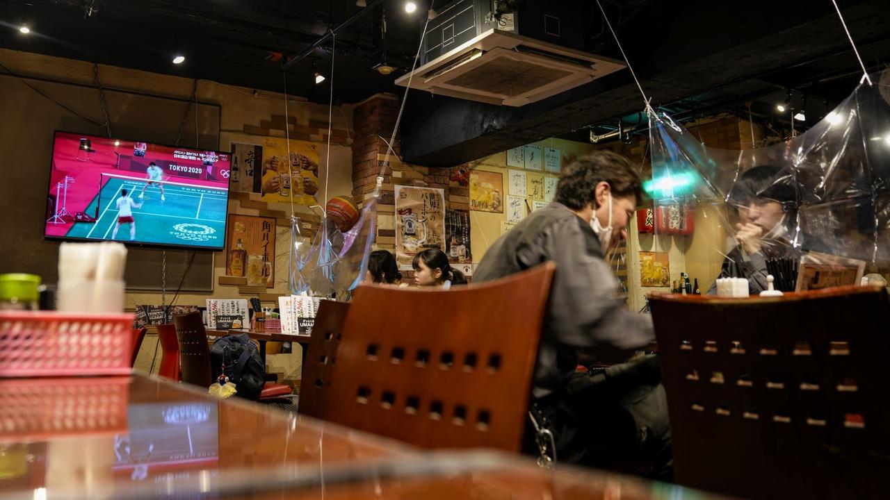 Die Olympia-Übertragungen laufen in einem Restaurant in Japan kaum beachtet im Hintergrund. Die Olympia-Übertragungen laufen in einem Restaurant in Japan kaum beachtet im Hintergrund.