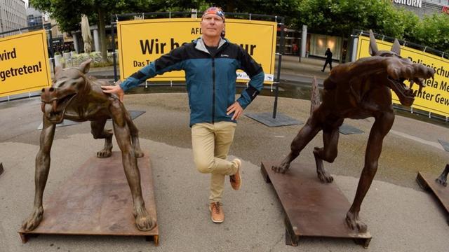 Der Brandenburger Künstler Rainer Opolka steht zwischen seinen Wolfsfiguren auf dem Königsplatz in Kassel.