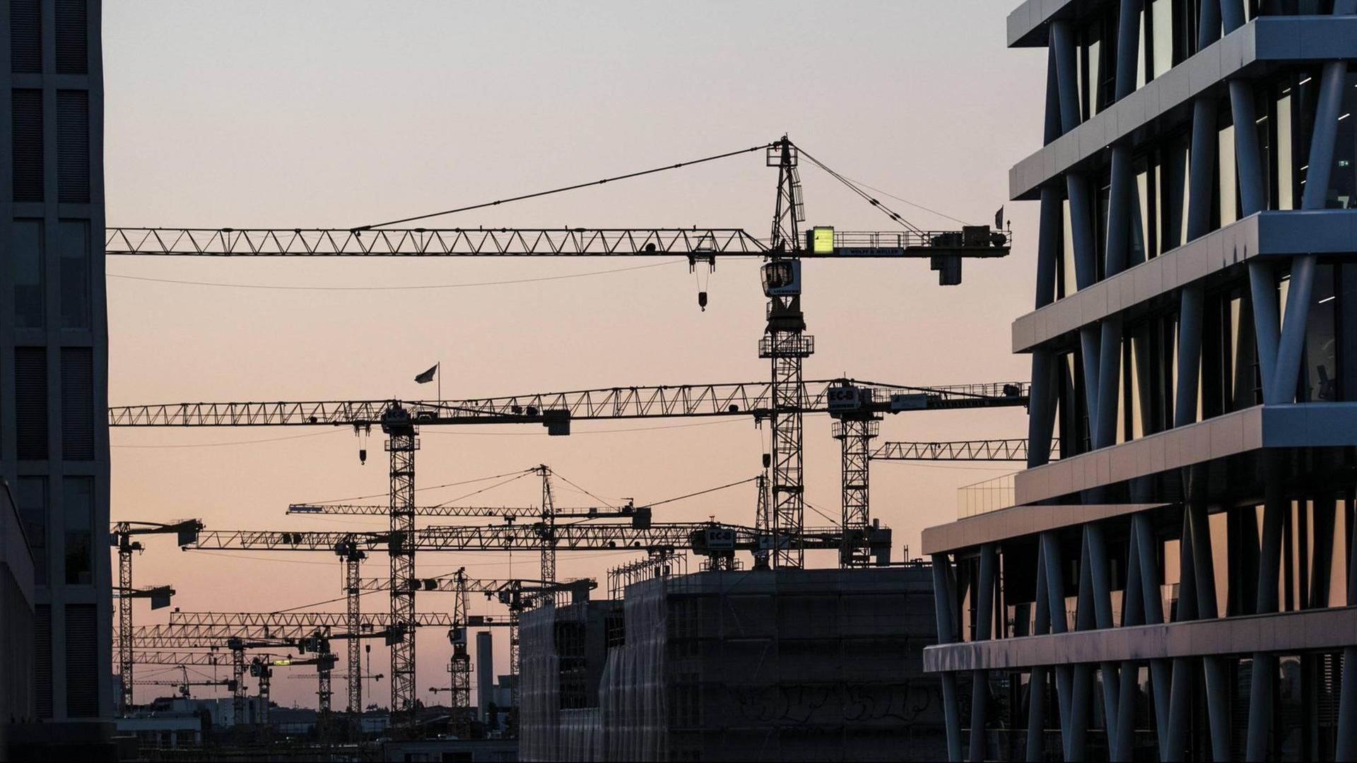 Kräne stehen zwischen Hausfassaden in Berlin. Kräne stehen zwischen Hausfassaden in Berlin.