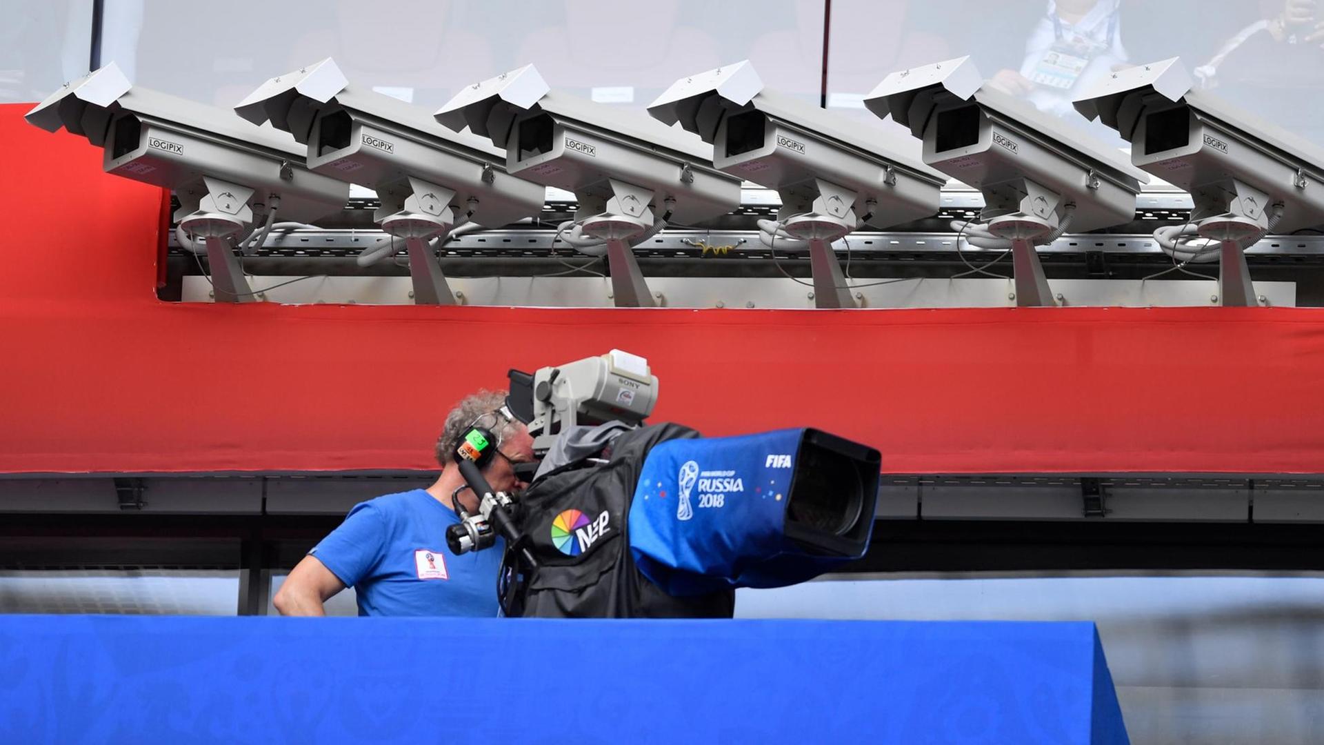 Ein TV-Kameramann filmt im Stadion unter Überwachungskameras. Ein TV-Kameramann filmt im Stadion unter Überwachungskameras.