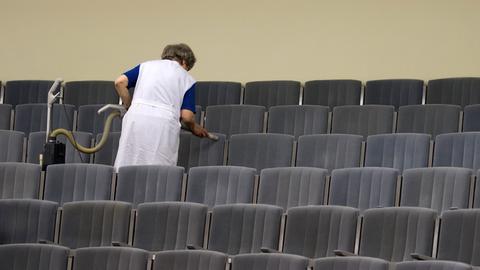 Eine Mitarbeiterin des Theaters in Meißen (Sachsen) reinigt mit einem Staubsauger die Sitze im Zuschauersaal des Theaters.