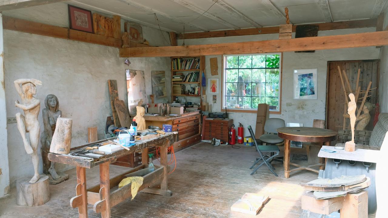 Blick in das Atelier von Christina Rode: Man sieht u.a. Skulpturen aus Holz, Bilder, Bücher. Blick in das Atelier von Christina Rode: Man sieht u.a. Skulpturen aus Holz, Bilder, Bücher.